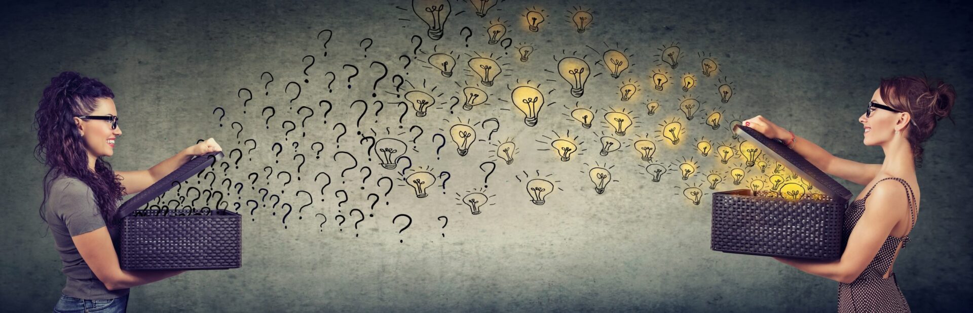 Photo of two girls stood opposite each other holding boxes, one with light bulbs flying out and the other with question marks