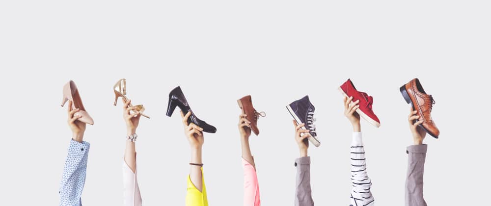 hands holding different styles of shoe