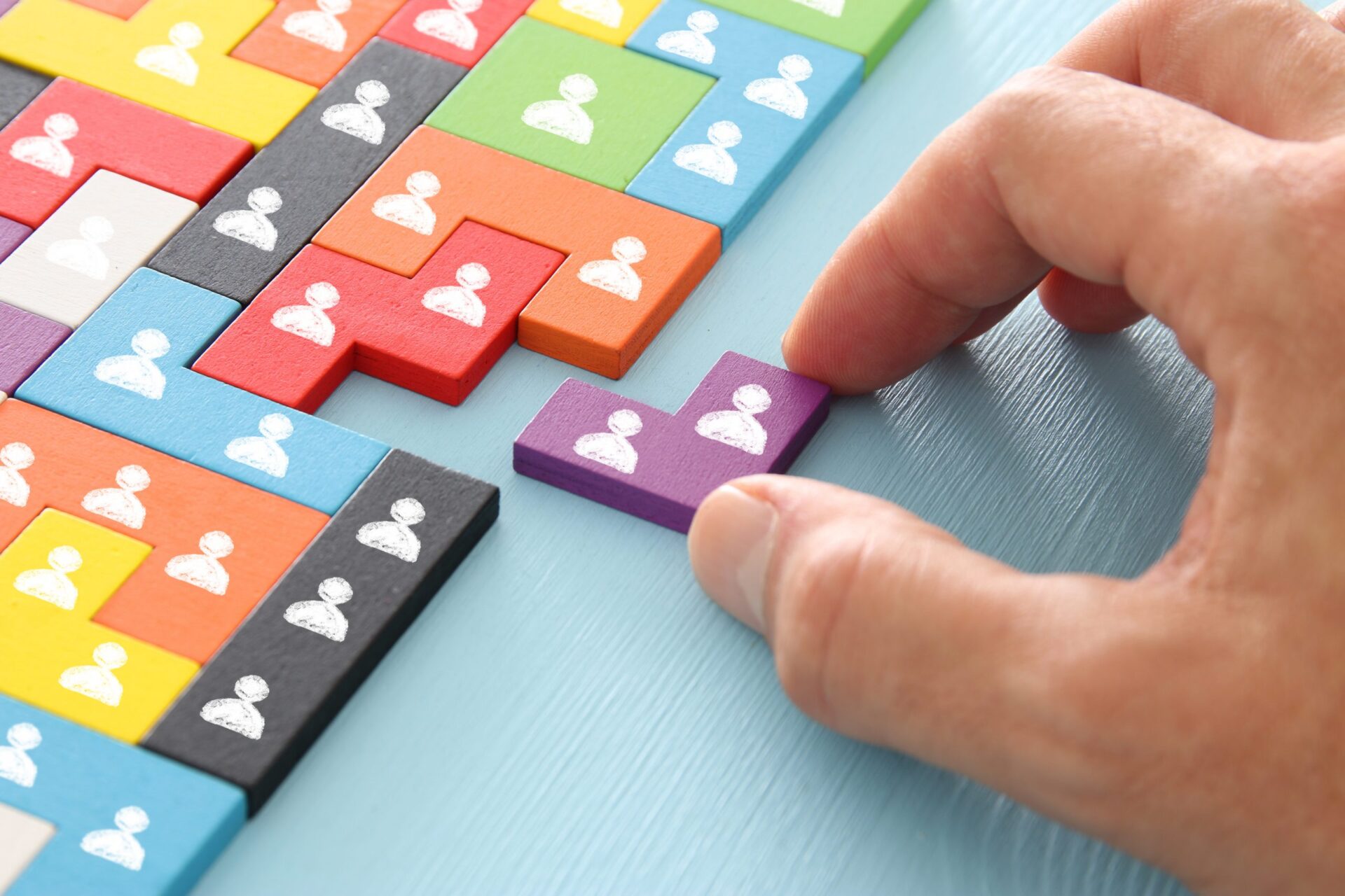 Photo of someone slotting wooden pieces with little people together