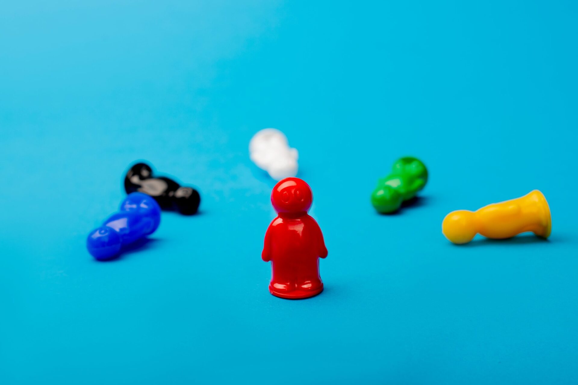 Photo of little game pieces all fallen around one still standing