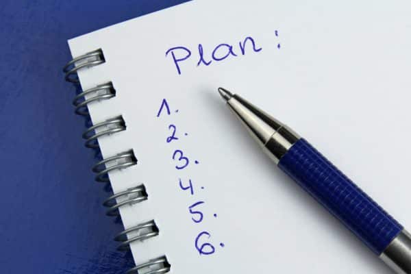 Notebook with a pen and the word plan at the top