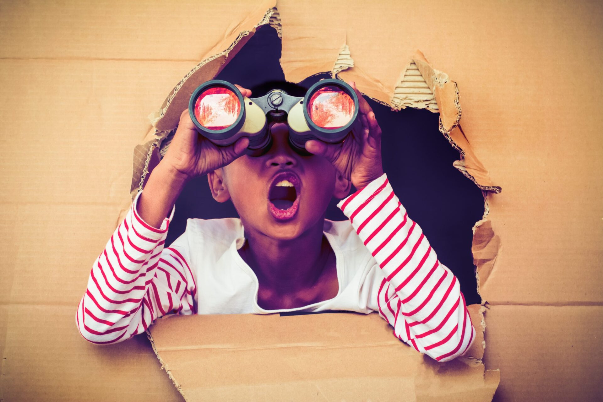 Photo of a young girl looking through binoculars