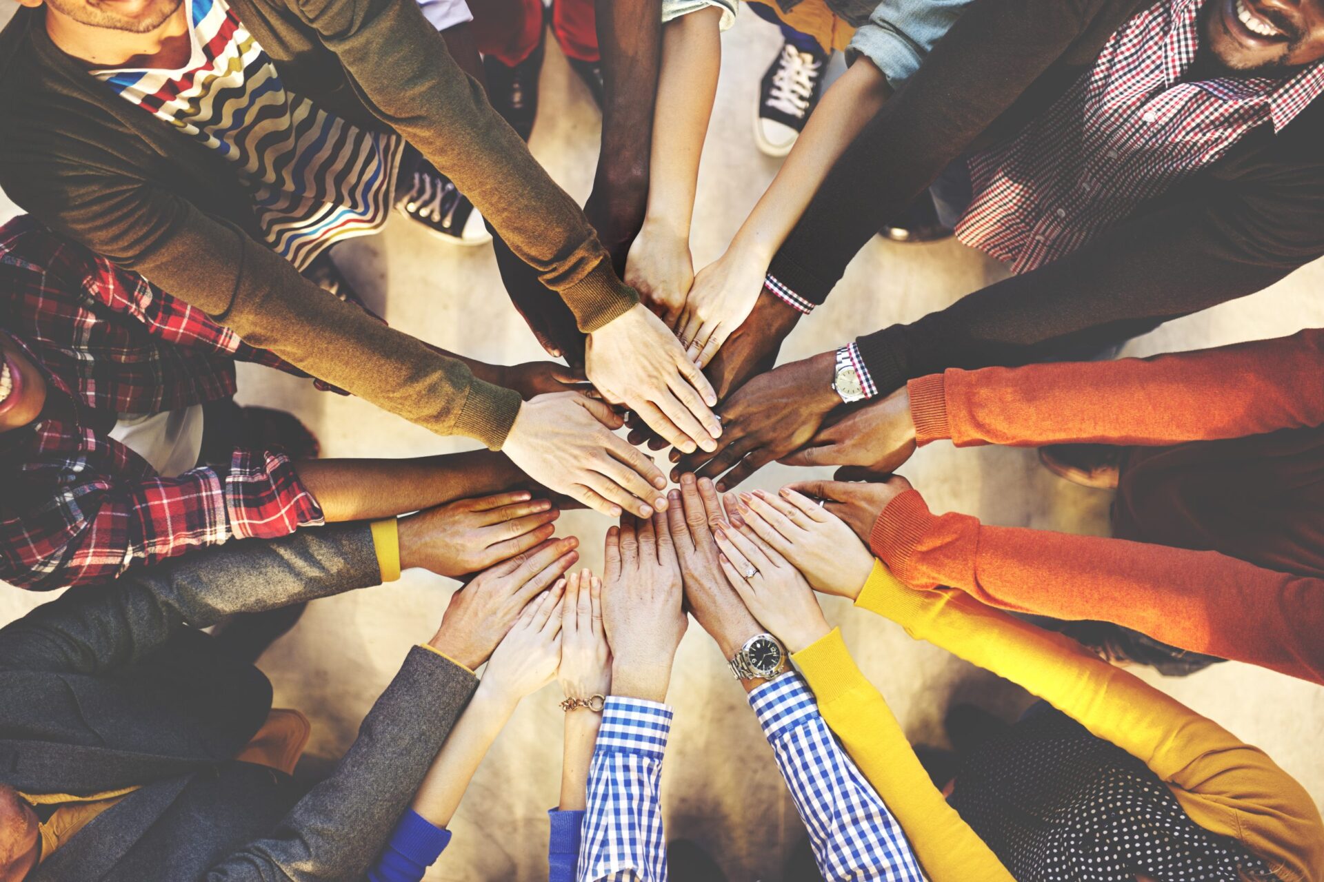 Photo of a group of people putting their hands together