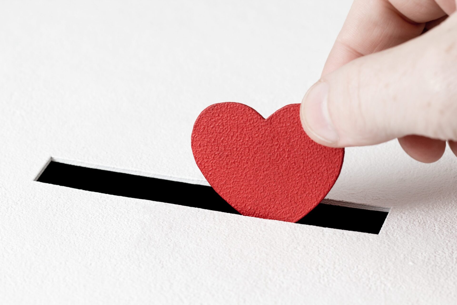 Photo of someone depositing a love heart into a box