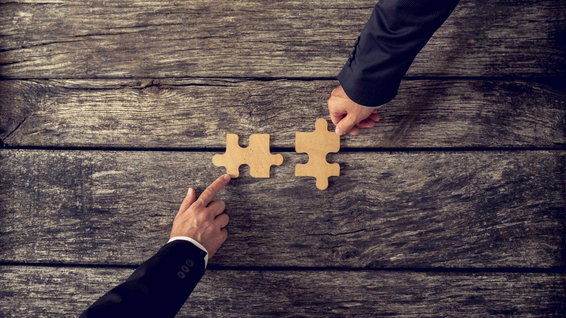 Photo of two people placing puzzle pieces on a table