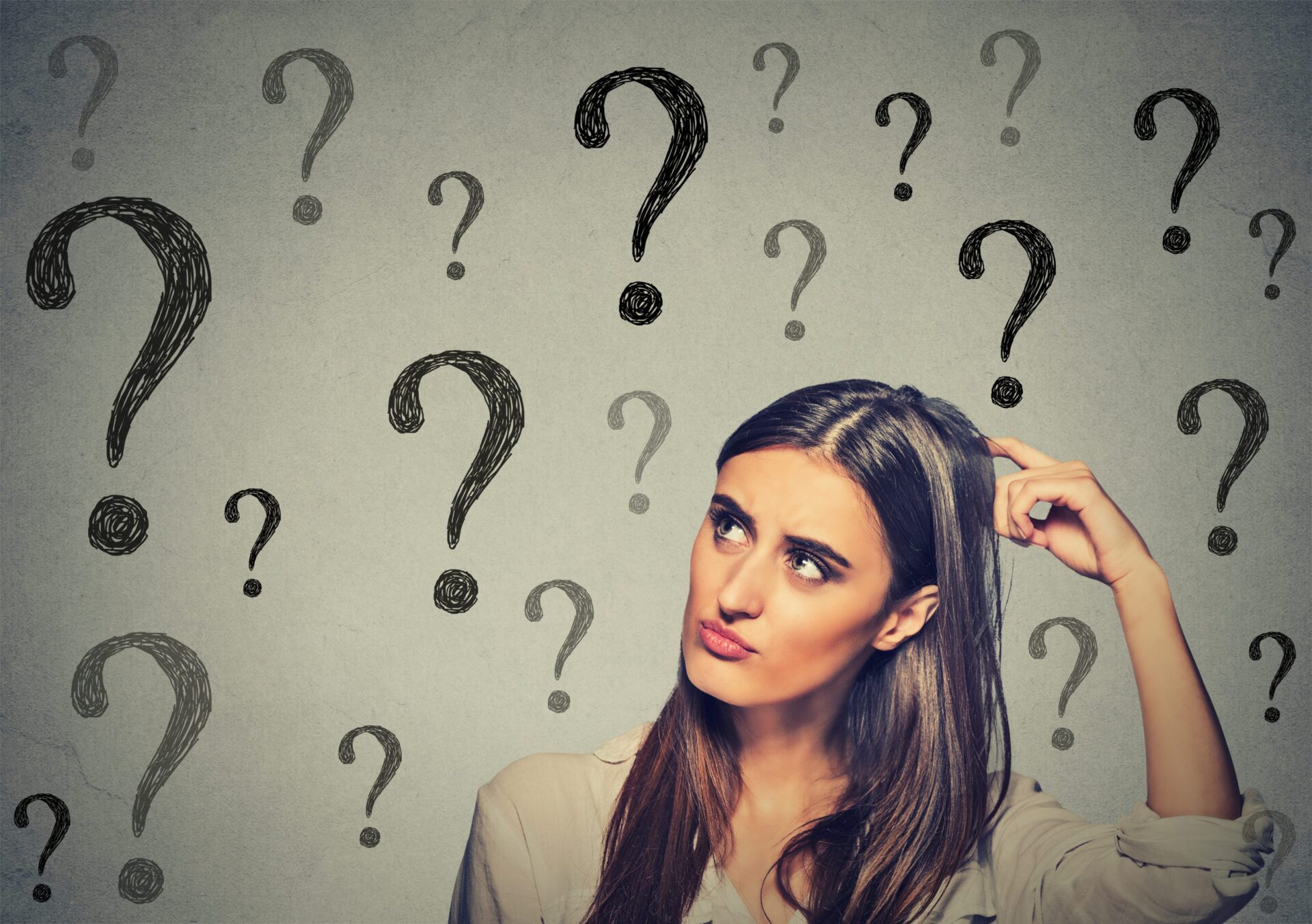 Photo of a confused women surrounded by question marks