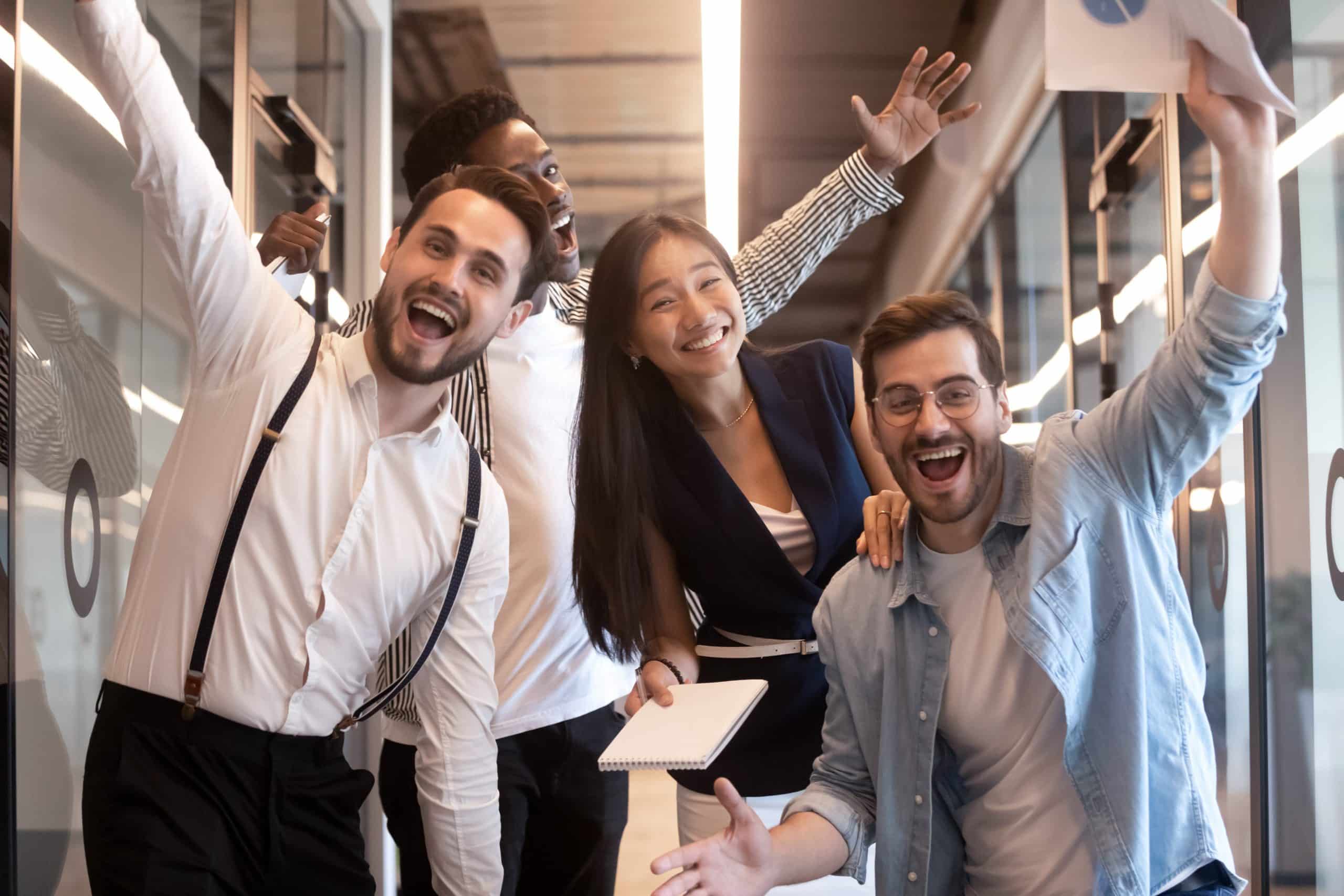 Excited funny multiethnic staff people business team stand in office looking at camera