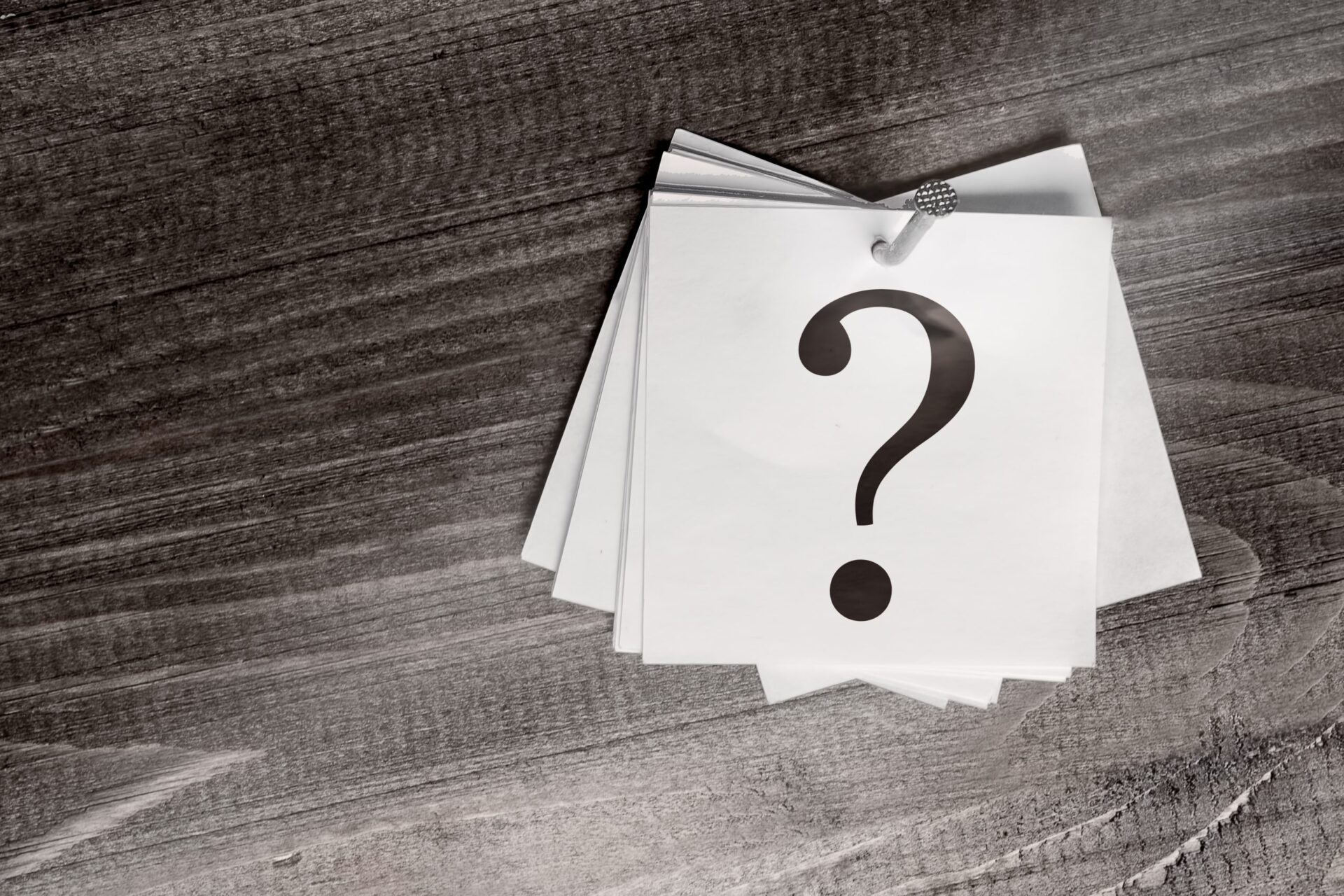Photo of a question mark in a post-it note pinned on the wall