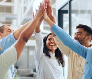 Group of employees happy and high-fiving on another
